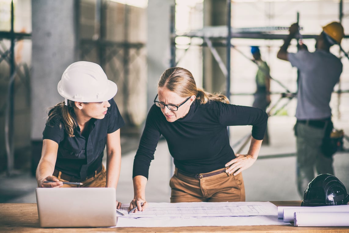 Female construction worker consulting an architect